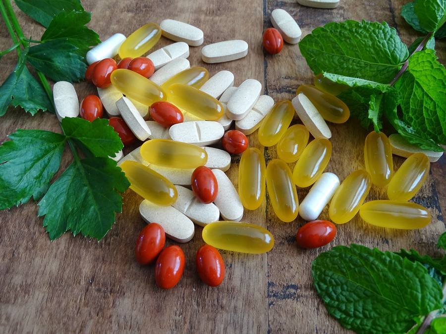 Natural supplements and vitamins for nerve health on wooden table