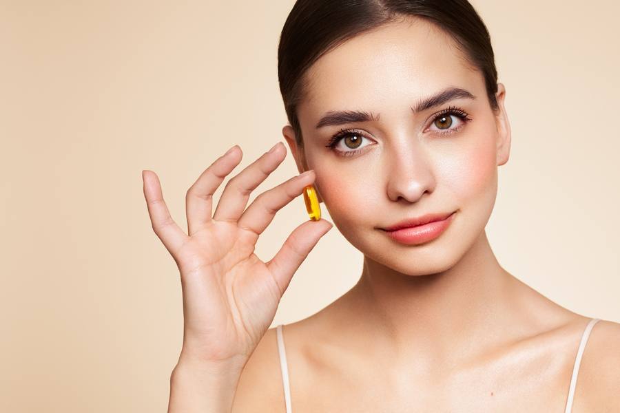Woman holding vitamin capsule for hearing support