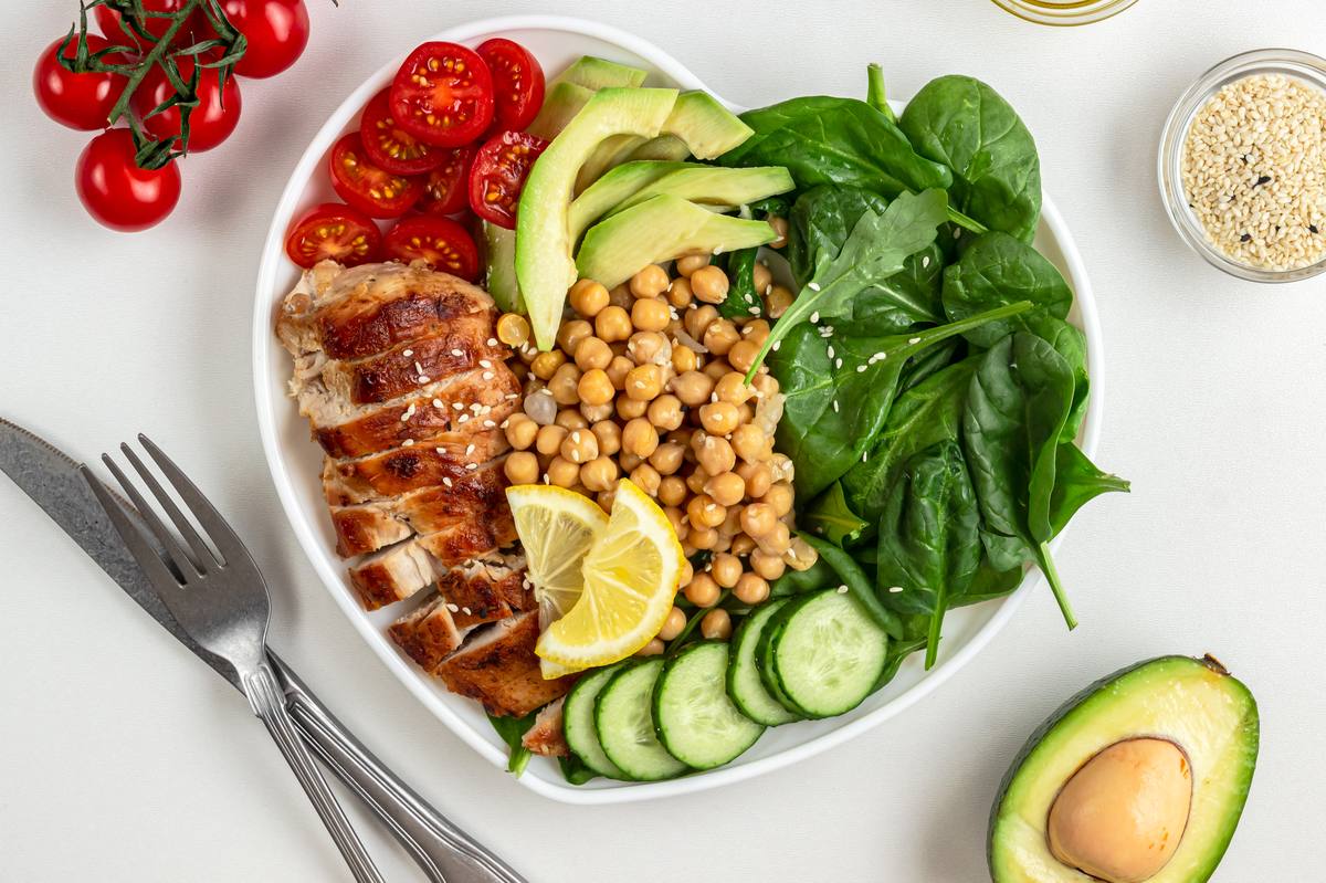 Colorful healthy chicken salad bowl with avocado and vegetables