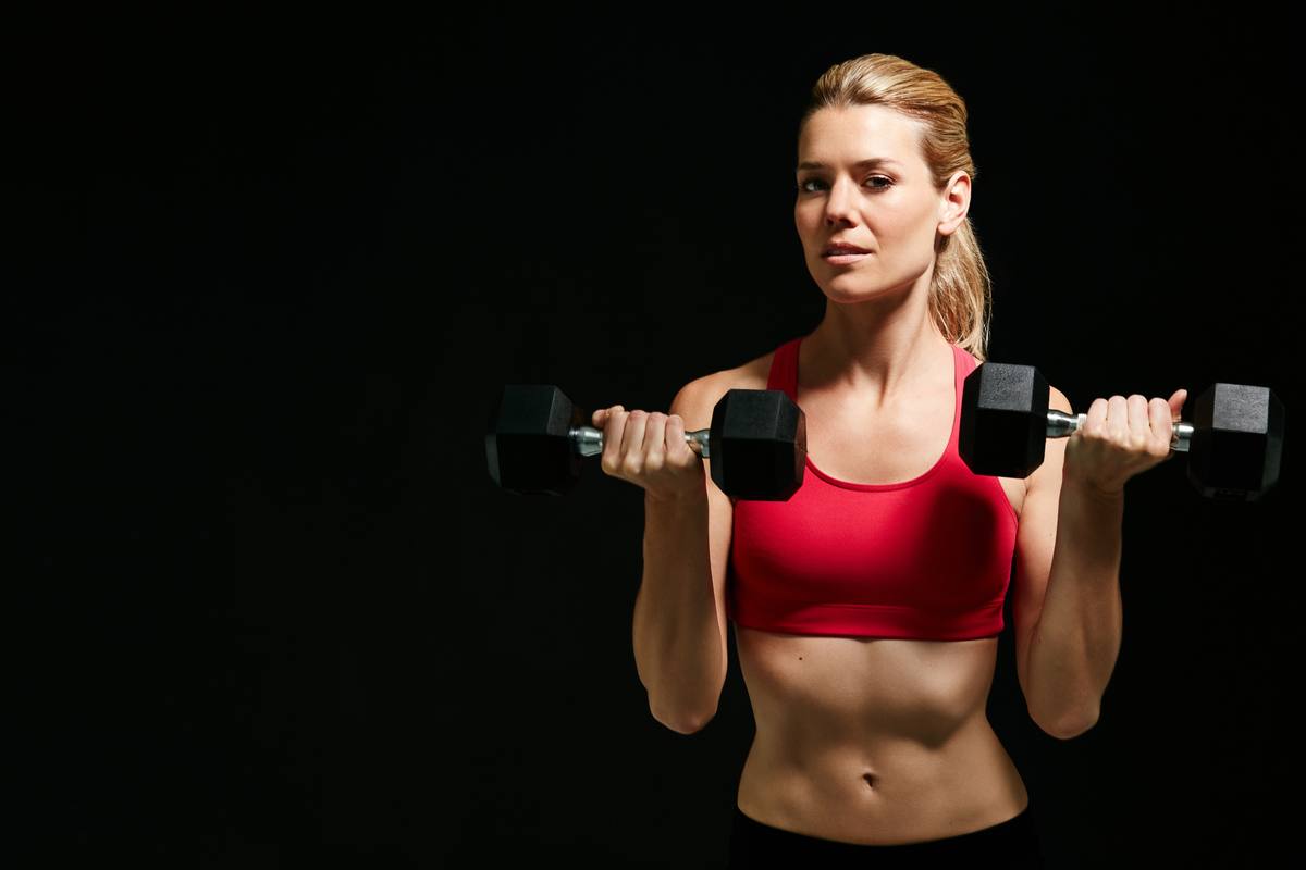 Woman strength training with dumbbells for weight loss after 40